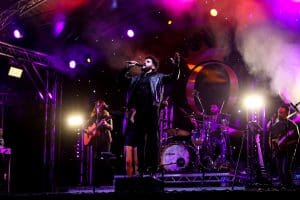Performer sings on stage at An Evening of Queen live concert